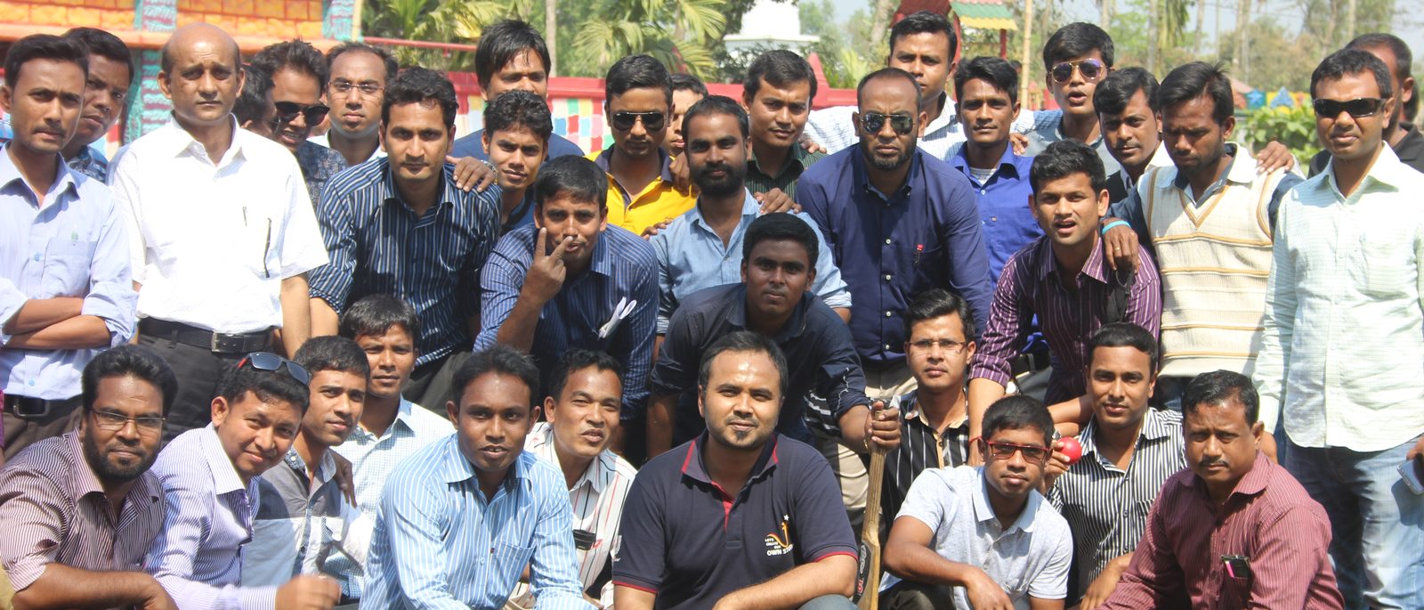 A large group of frontline distribution workers gathered outdoors at a training day in Bangladesh.