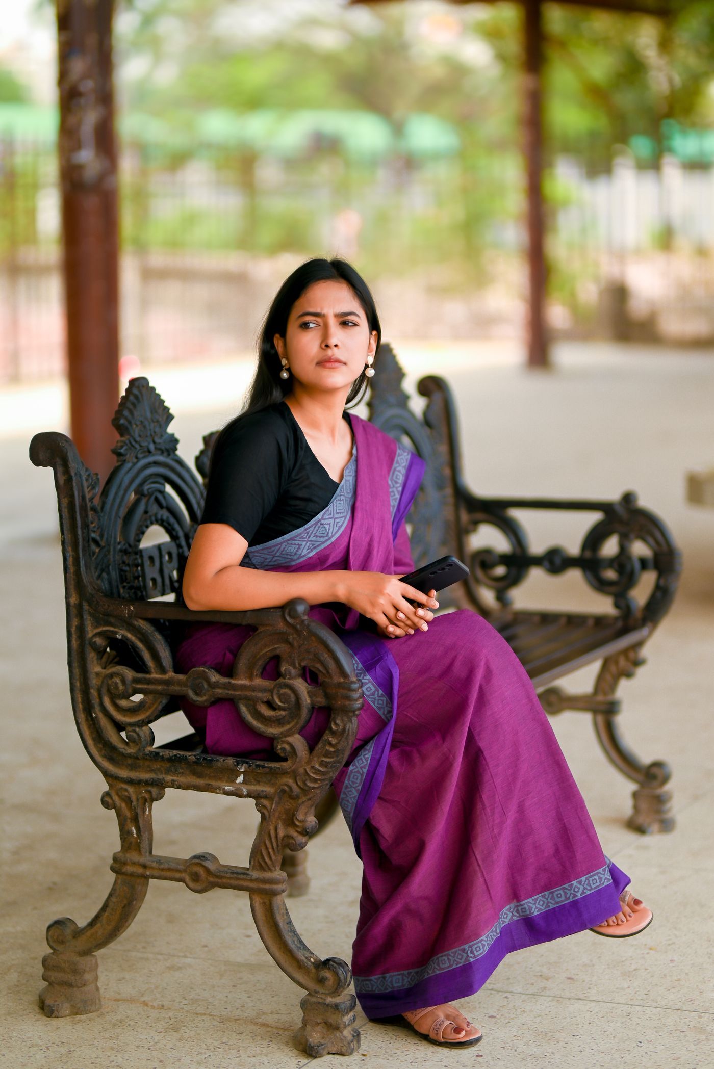 A woman holding her phone at a railway station in Dhaka, Bangladesh